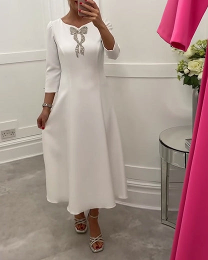 Elegant, plain dress with bow and three-quarter sleeves